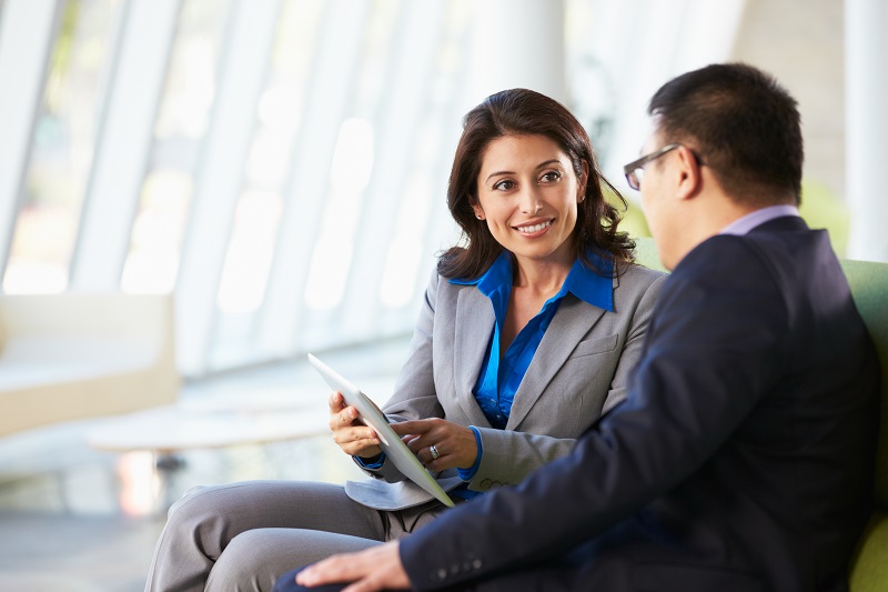 Two workers review content marketing on a tablet.