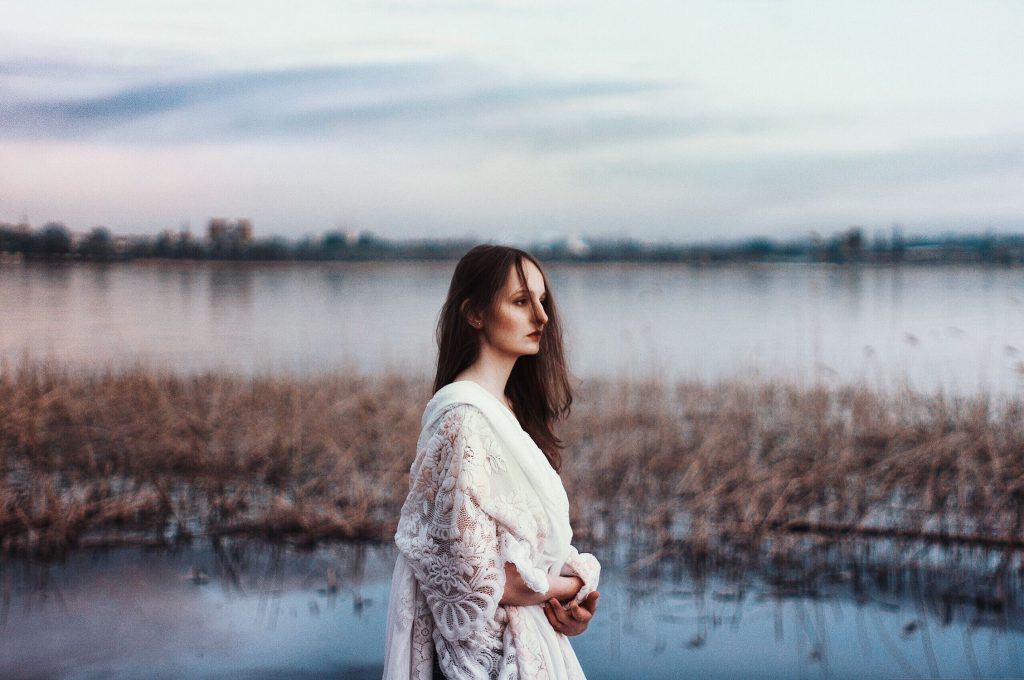 A woman walking in a marsh.