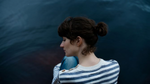 A woman, sitting, with her back turned.