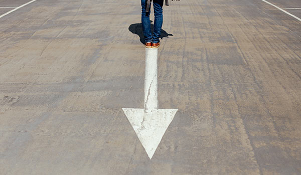 Someone standing behind a painted arrow.