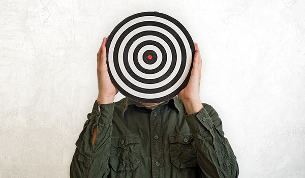 A person holding a target in front of their face.