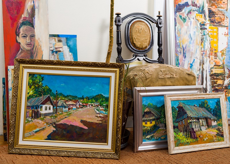 A collection of paintings on a shelf.