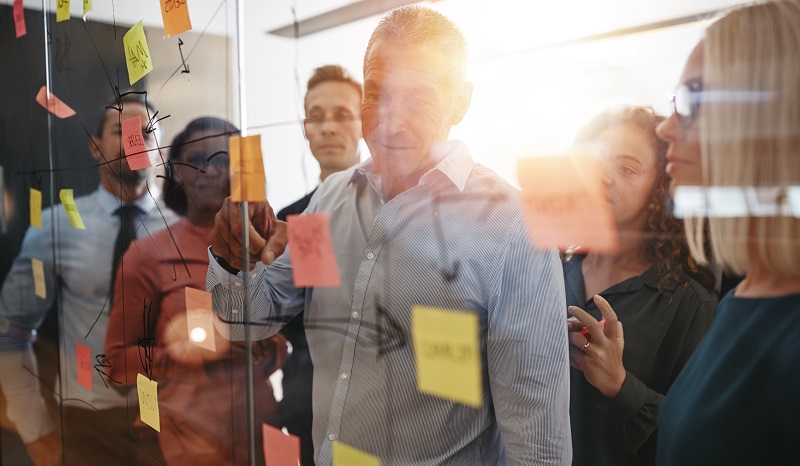 A group of coworkers reviewing notes on a board.