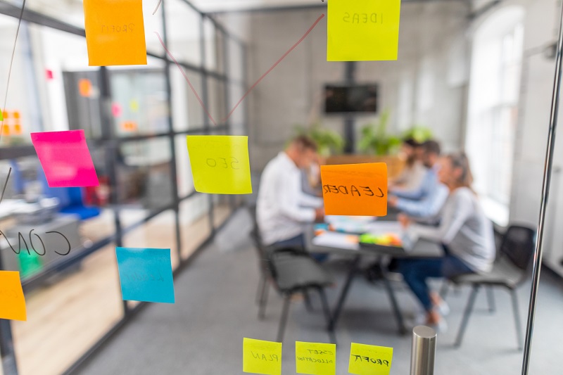 A group of team works in front of a clear door.