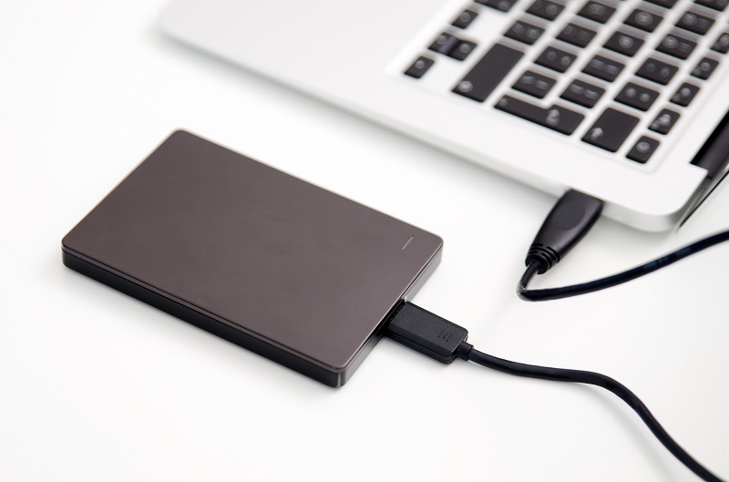 A picture of an external hard drive plugged into a laptop.