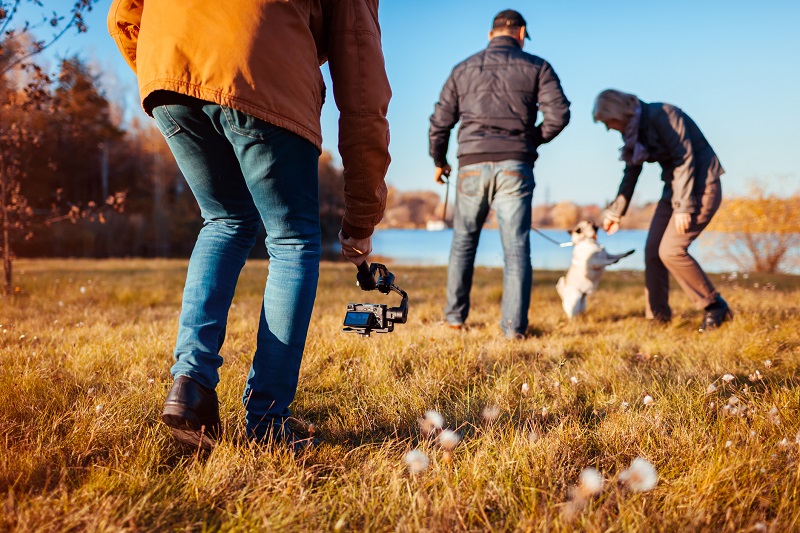 A picture of someone filming a dog.