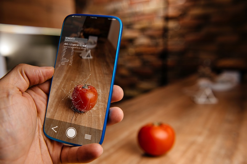 A mobile device taking a photo of a tomato.