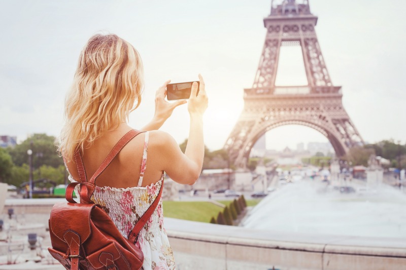 A woman takes a photo with her smart phone.