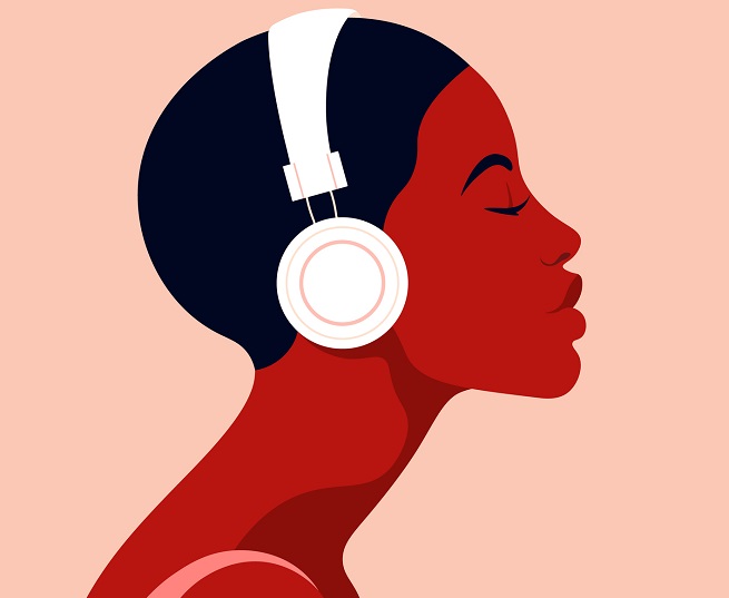 A woman listens to headphones.