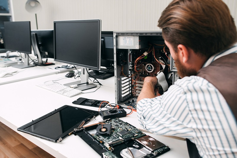 An IT member fixes a computer.