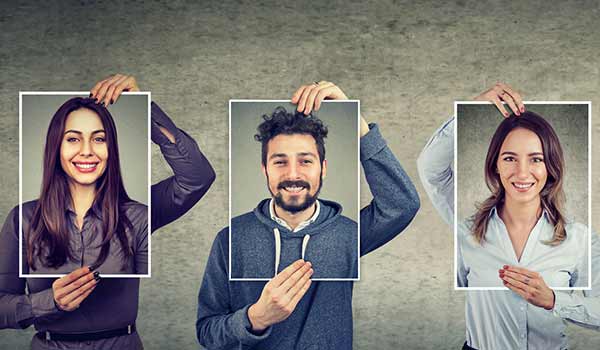 Three different people holding a self-portrait over their face.