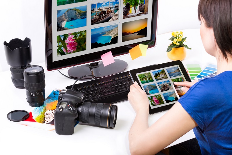 A woman browses photos on a tablet.