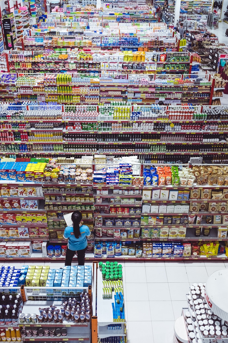 A woman counts items in a store.