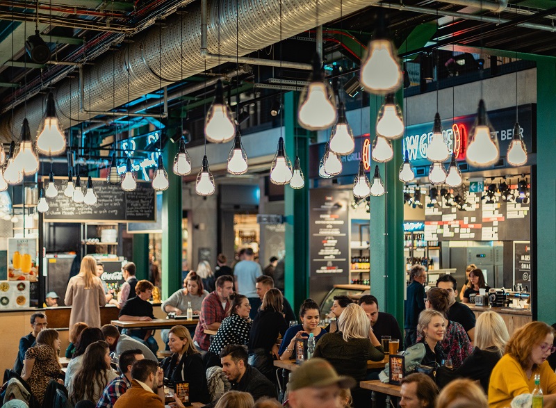 A lighted cafe with a lot of customers.