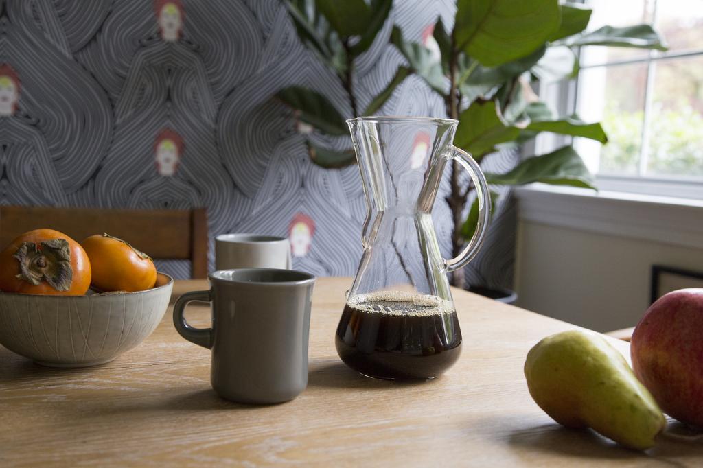 A photograph of cups and fruits on a table.