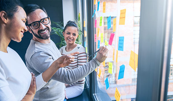 Workers creating a plan on a whiteboard.