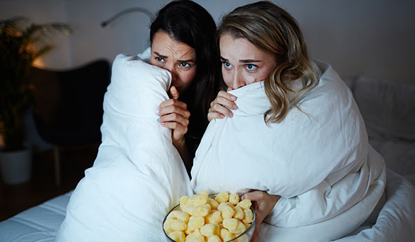 Two women watching a scary film.