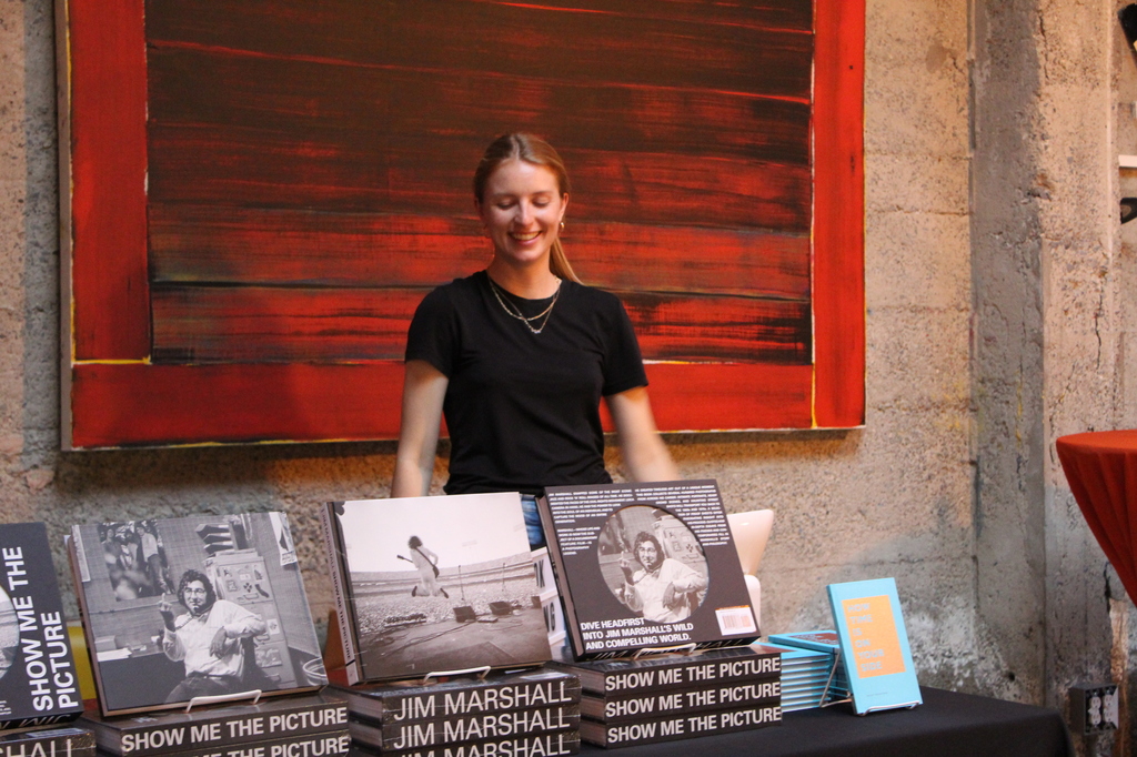 A person standing behind a book stall.