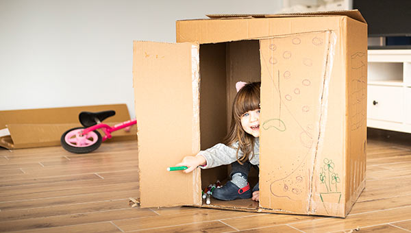 A young child playing inside a box.