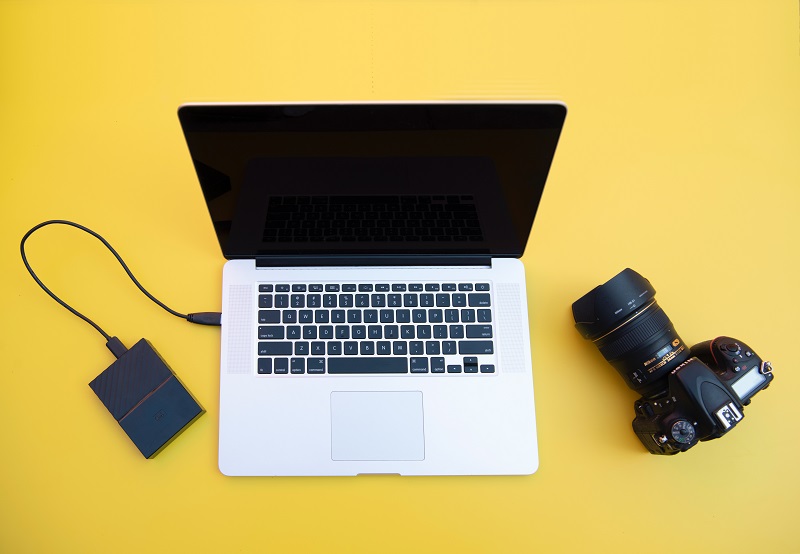 A camera next to a laptop.