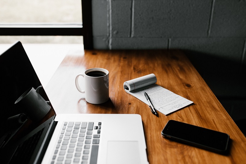 A laptop and mobile device on a desk.