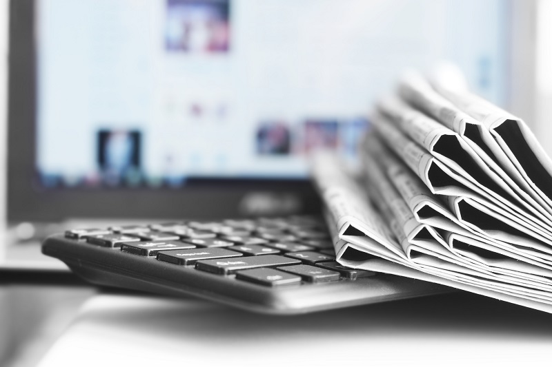 Newspapers on top of a keyboard.