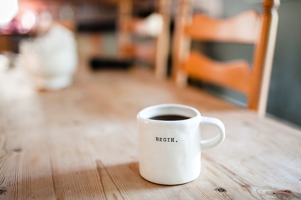 A coffee cup that reads 'Begin'.