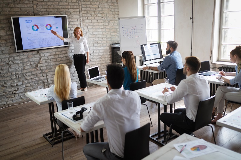 A woman presents graphs to a class.