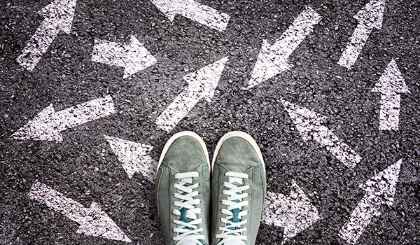 A pair of feet amongst arrows on the ground.