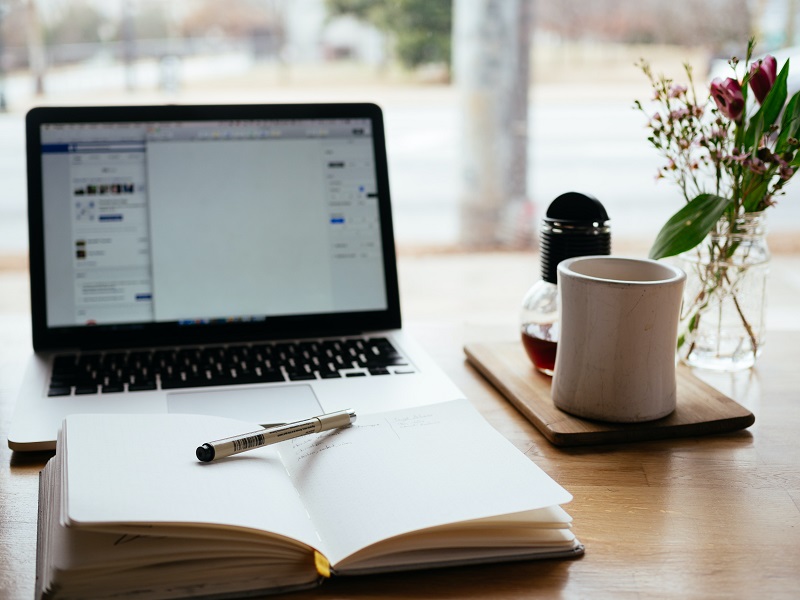 A computer and journal side-by-side.