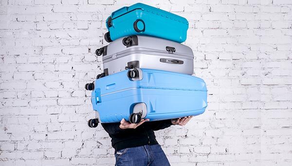 A person overwhelmed by luggage.