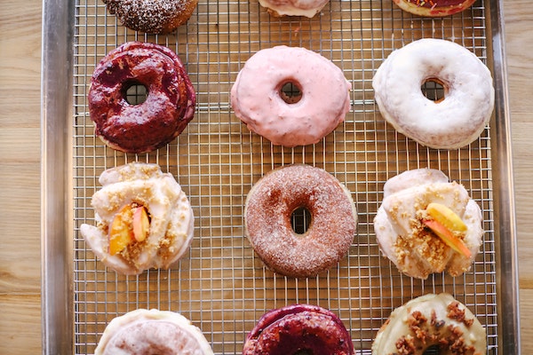 Decorated donuts lined up on a cooling rack.