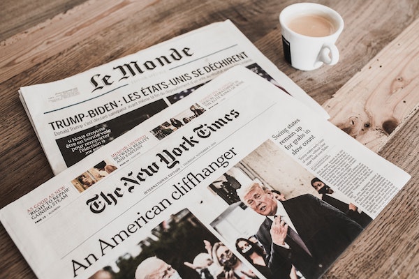 Front pages of New York Times and Le Monde print editions.