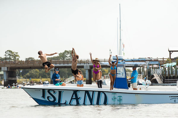 Group of people jumping from Island Brands boat